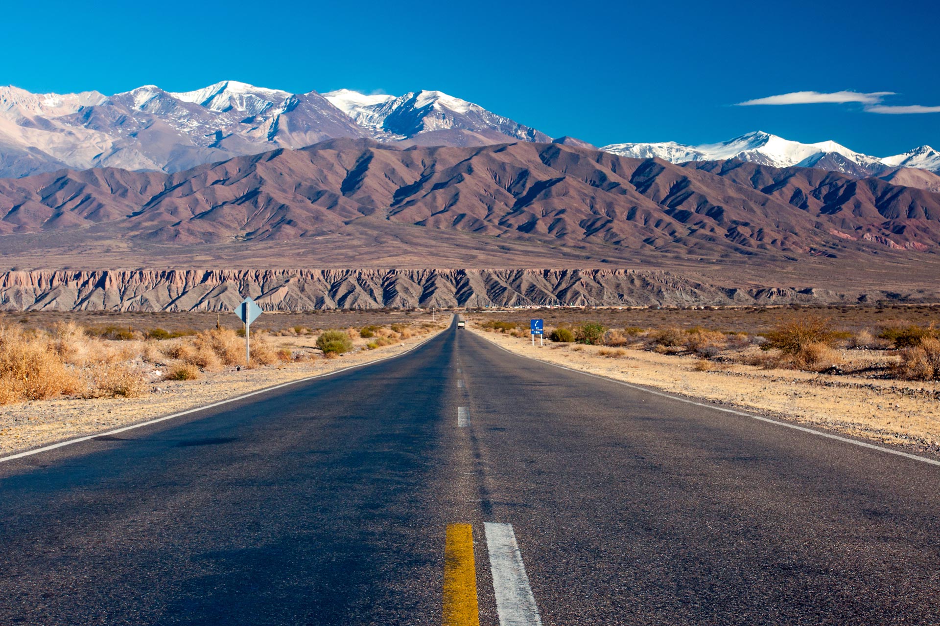An empty road with the Andes mountain range on the backend in Cordillera de los Andes, Argentina